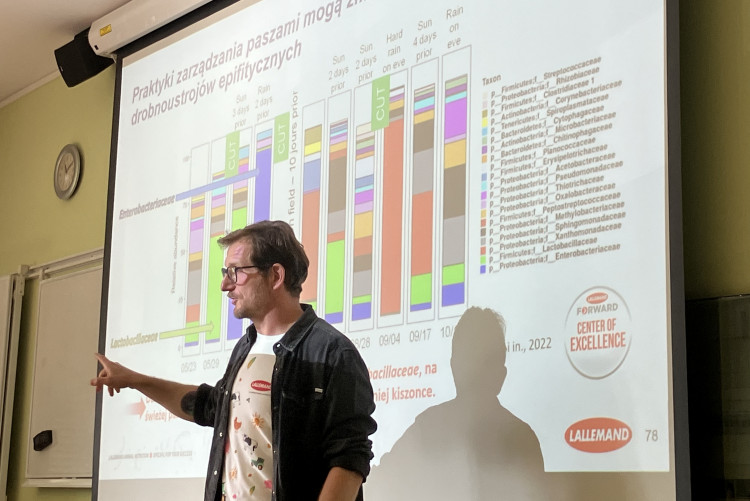 Pan mgr inż Maiej Piękniewski prezentujacy różnorodność mikroorganizmów zidentyfikowanych w zakiszanym materiale