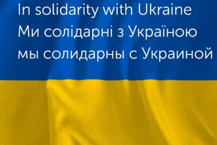 Link do strony WWZ pomaga Ukrainie - flaga Ukrainy z wielojęzycznym napisem Solidarni z Ukrainą